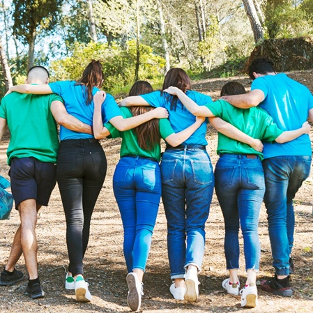 Eine Gruppe junger Menschen, die in einer Reihe umarmt nach vorne gehen.